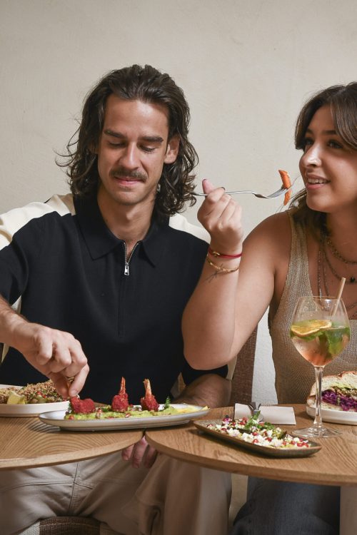 Grande table gourmande avec assiettes méditerranéennes à partager, houmous, dips et cocktails chez Dip Honest Food, une expérience idéale pour un dîner vivant et généreux