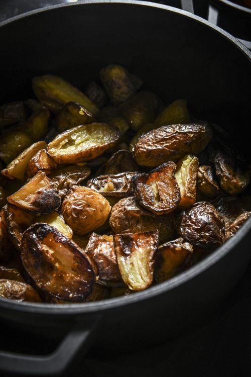 Pommes de terre grenailles rôties dans une casserole noire, dorées et croustillantes.